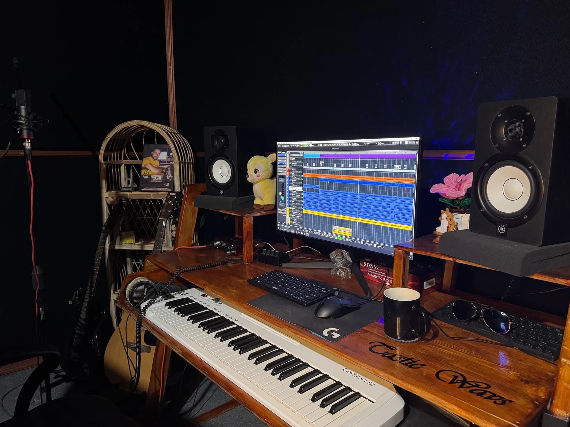 Close-up of the Tastic Wavs production desk with monitor speakers, computer display, and MIDI keyboard.